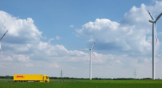 DHL truck driving in landscape with windmills