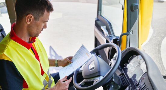 DHL truck driver checking paperwork