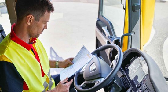 DHL truck driver checking paperwork