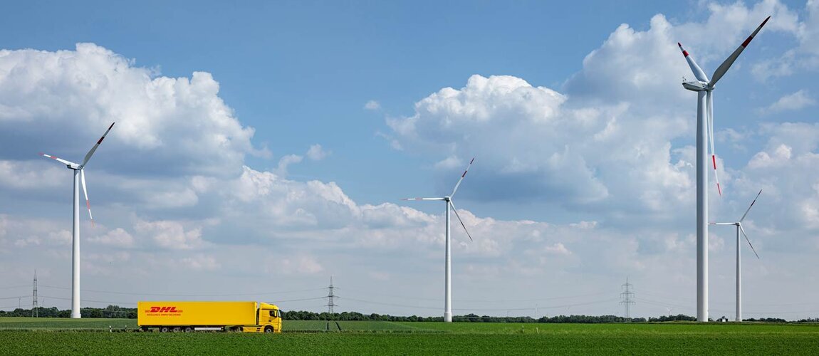 DHL truck driving in landscape with windmills