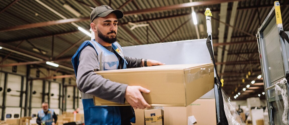 DHL employee lifting heavy parcel