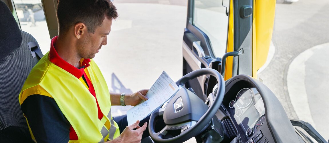 DHL truck driver checking paperwork