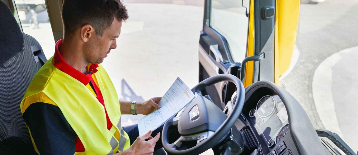 DHL truck driver checking paperwork
