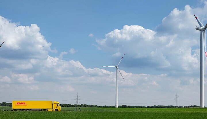 DHL truck driving in landscape with windmills