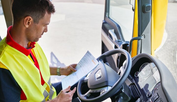 DHL truck driver checking paperwork