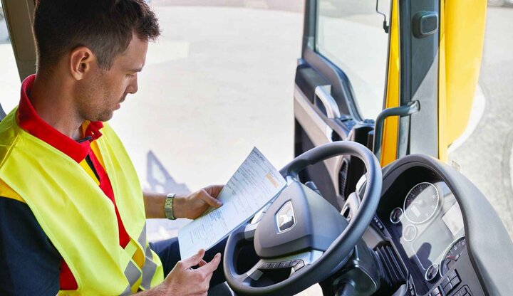 DHL truck driver checking paperwork