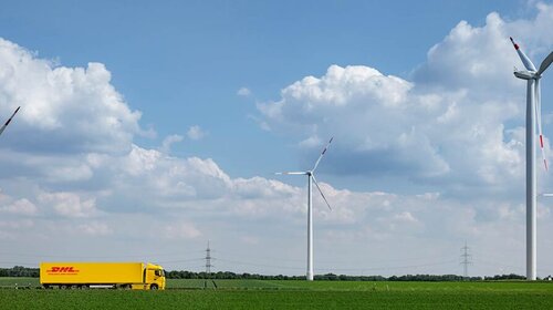 DHL truck driving in landscape with windmills