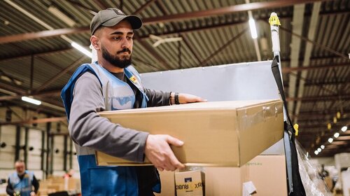 DHL employee lifting heavy parcel