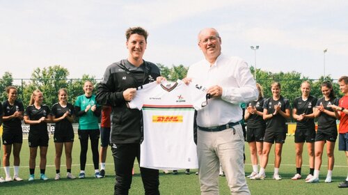 Women Manager Aline Zeler en CEO Frank Van Hille tonen het nieuwe OH Leuven Women shirt.