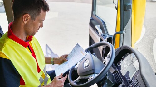 DHL truck driver checking paperwork
