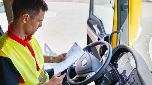 DHL truck driver checking paperwork
