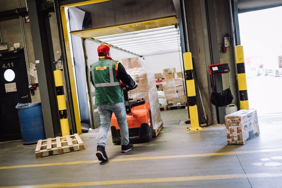 DHL driver loading pallet into truck