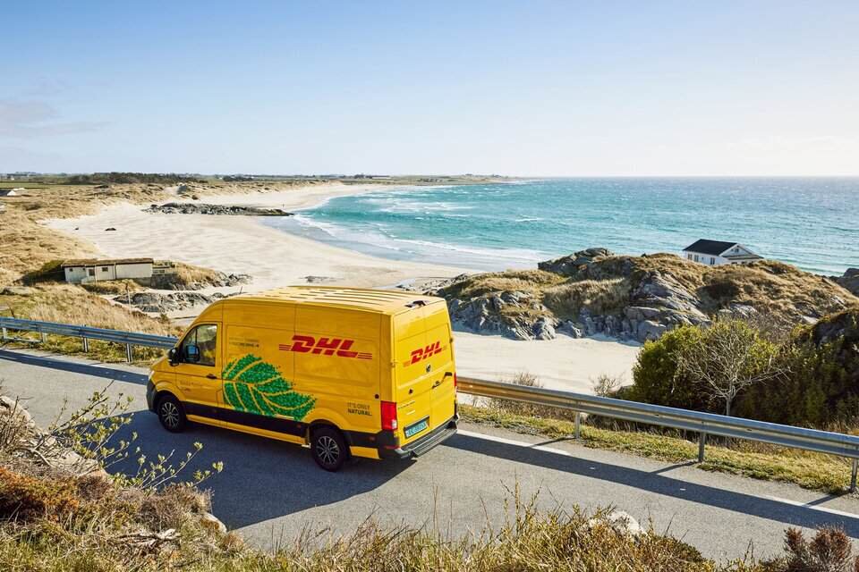 DHL electric van driving along the coast