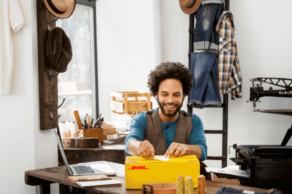 man preparing a parcel to ship with DHL