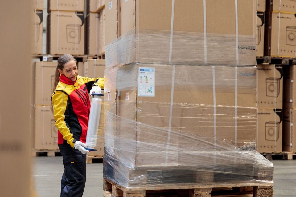 DHL employee wrapping a pallet