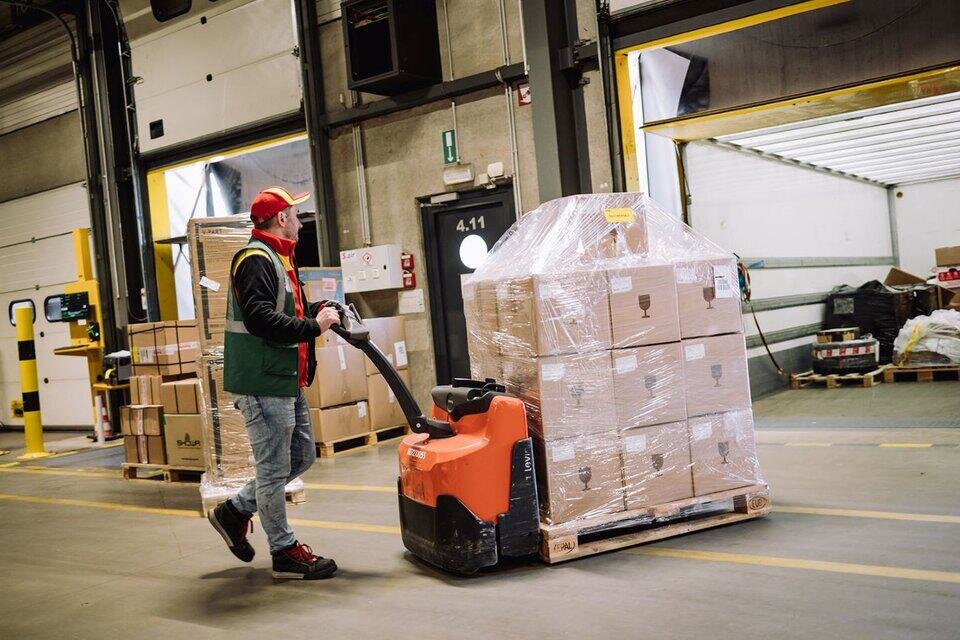 DHL driver loading pallet into truck
