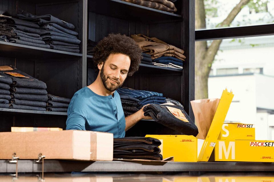 man packing clothes to ship with DHL