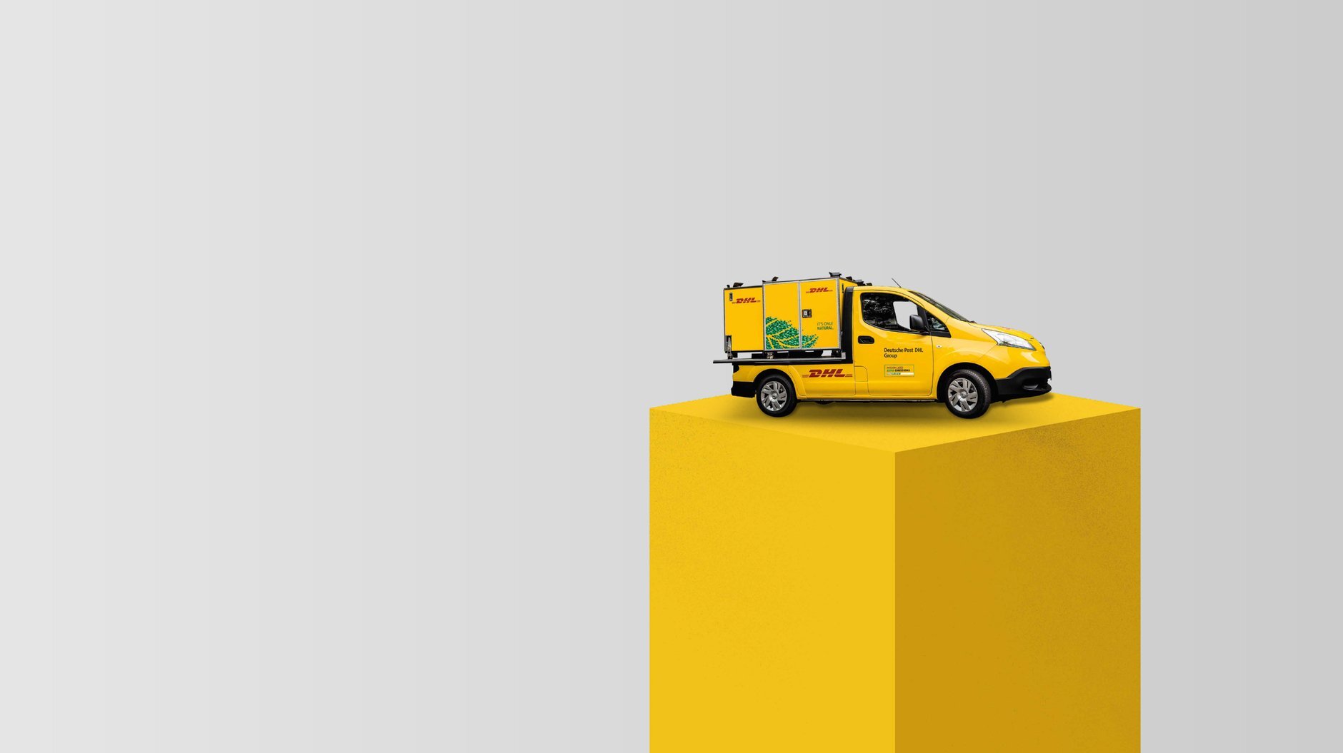 miniature DHL van on yellow pillar
