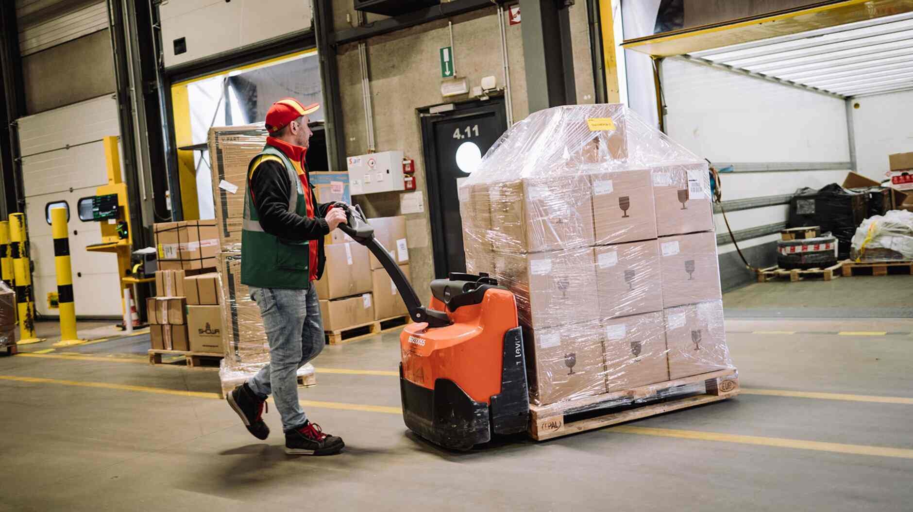 DHL driver with pallet in warehouse